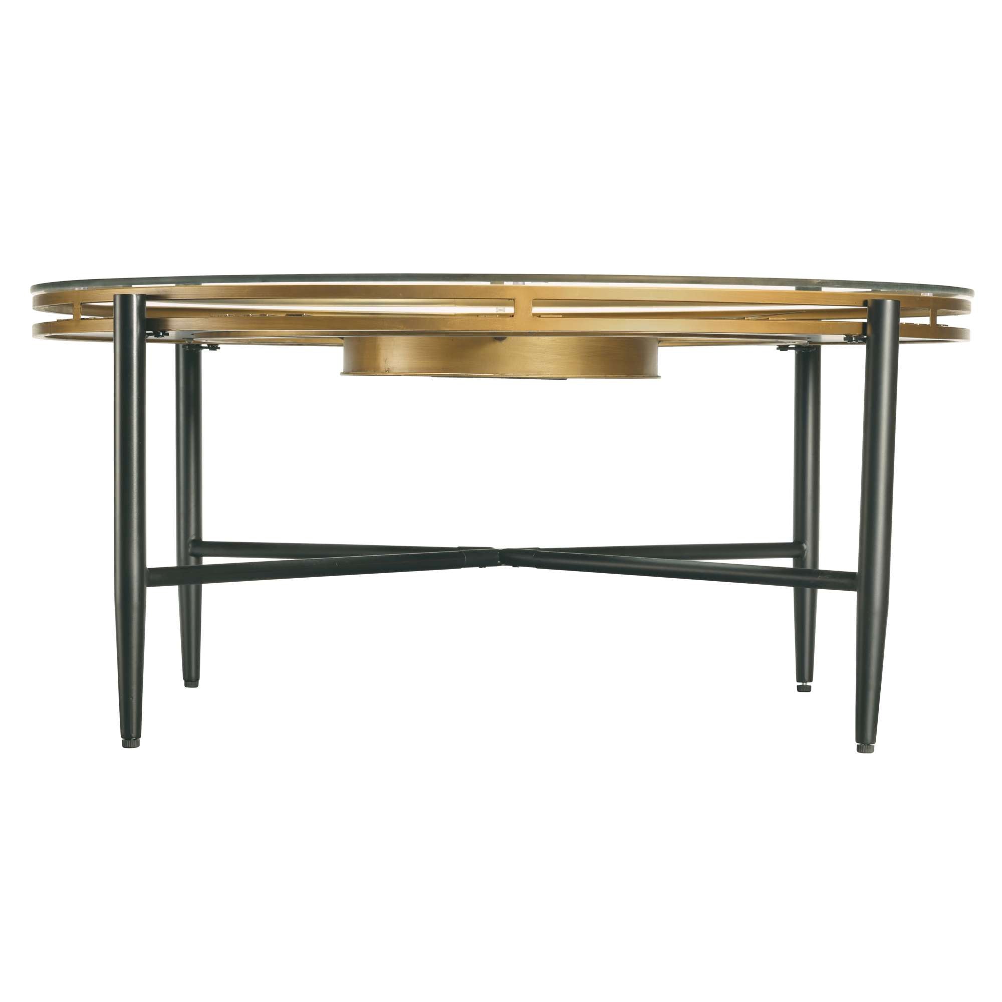Round coffee table with a gold top and black legs.