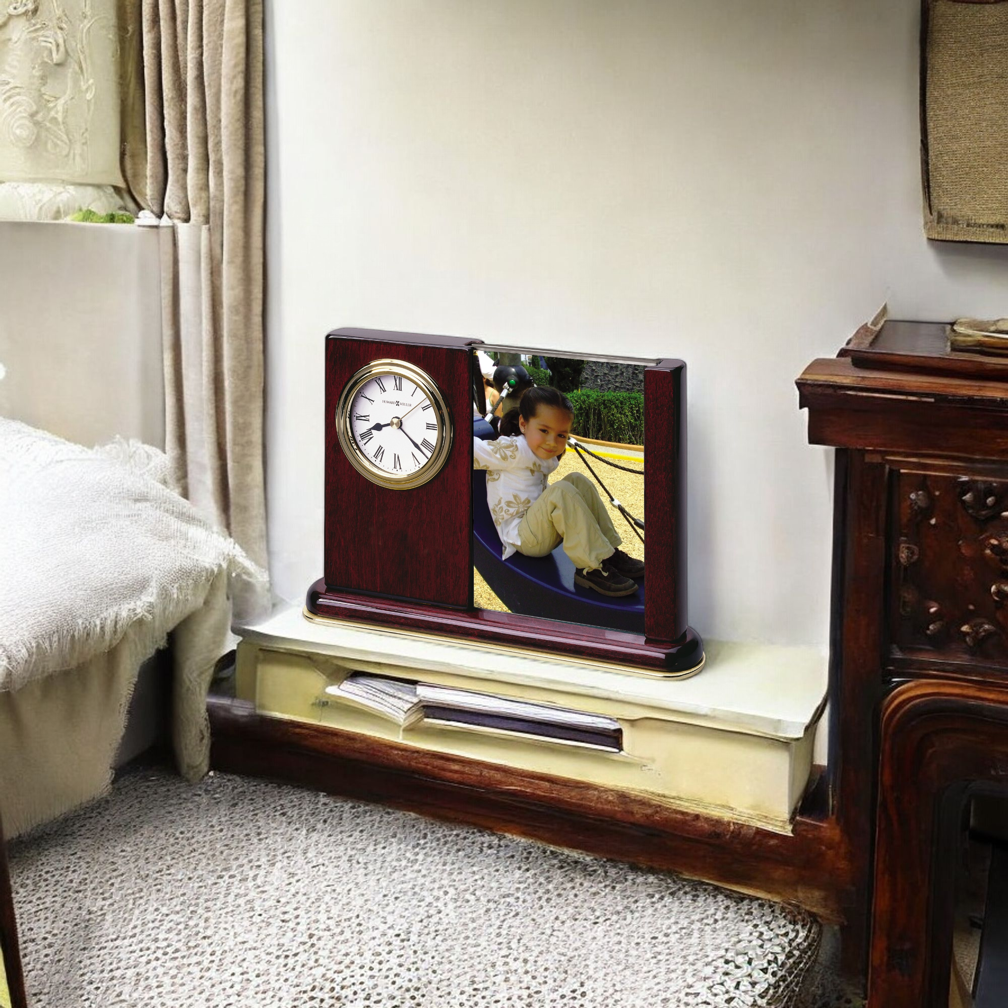 A wooden clock on a shelf with a framed photo of a child in a playground.