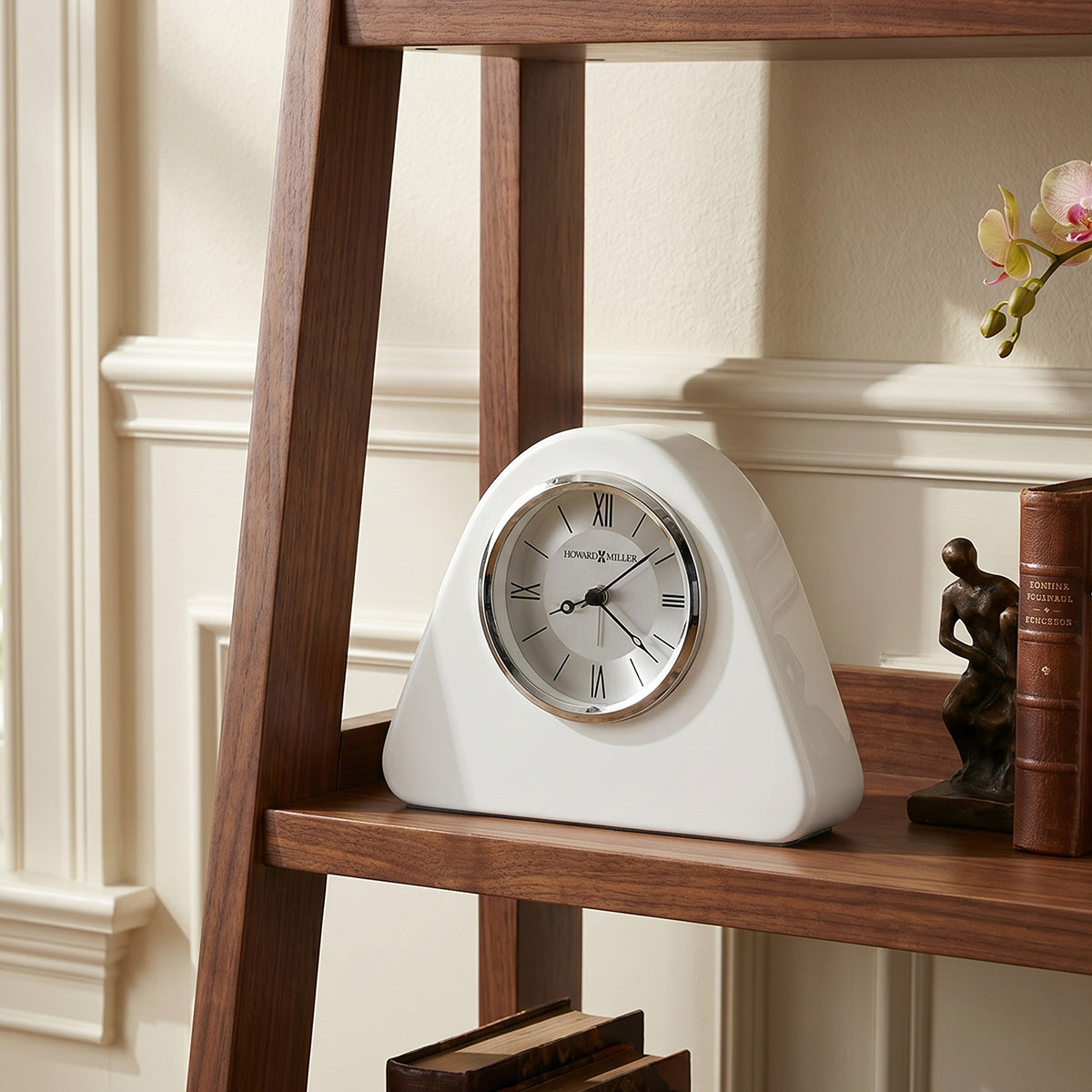 White clock on a wooden shelf with decorative items