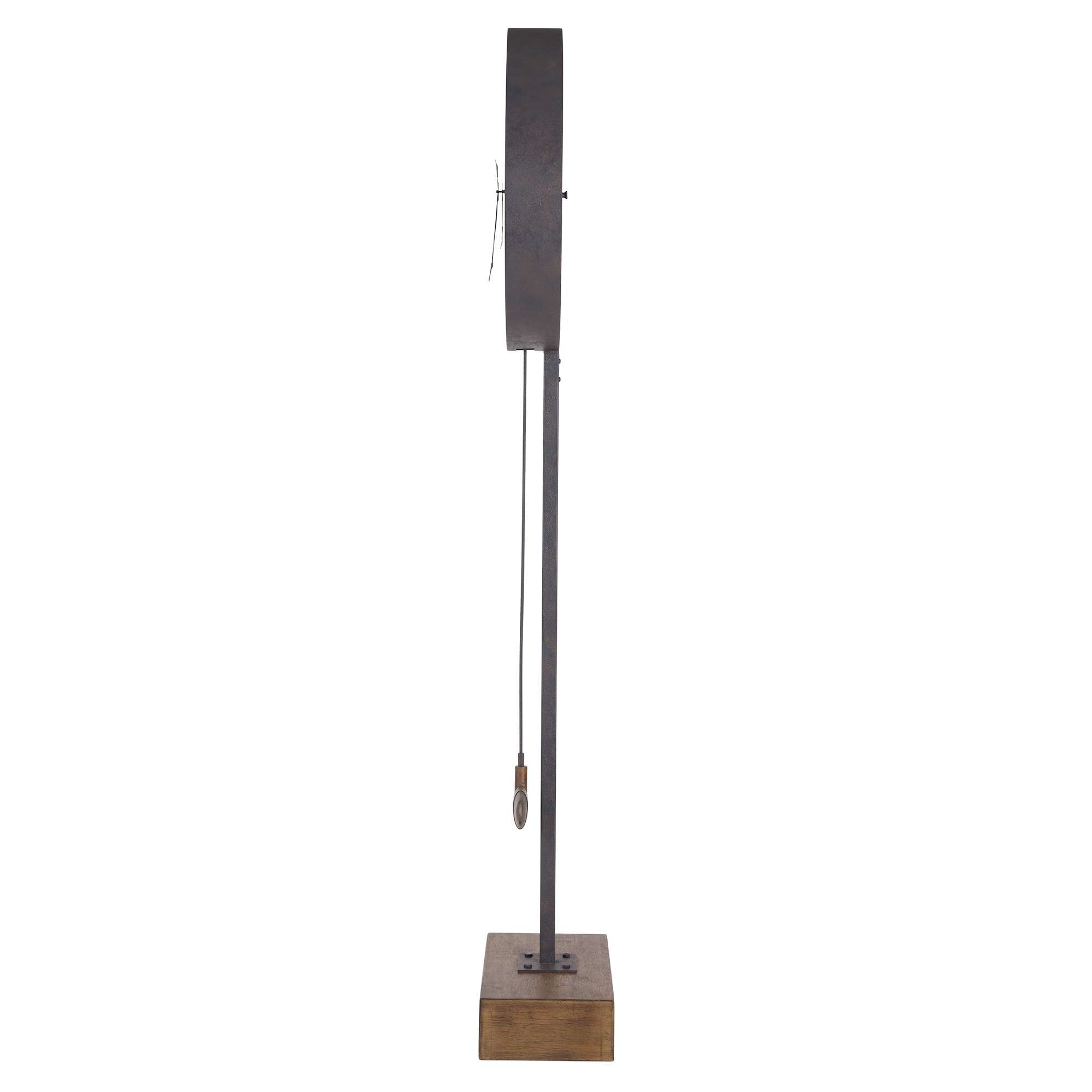 A minimalist wall clock with a slender metal stand and a wooden base.