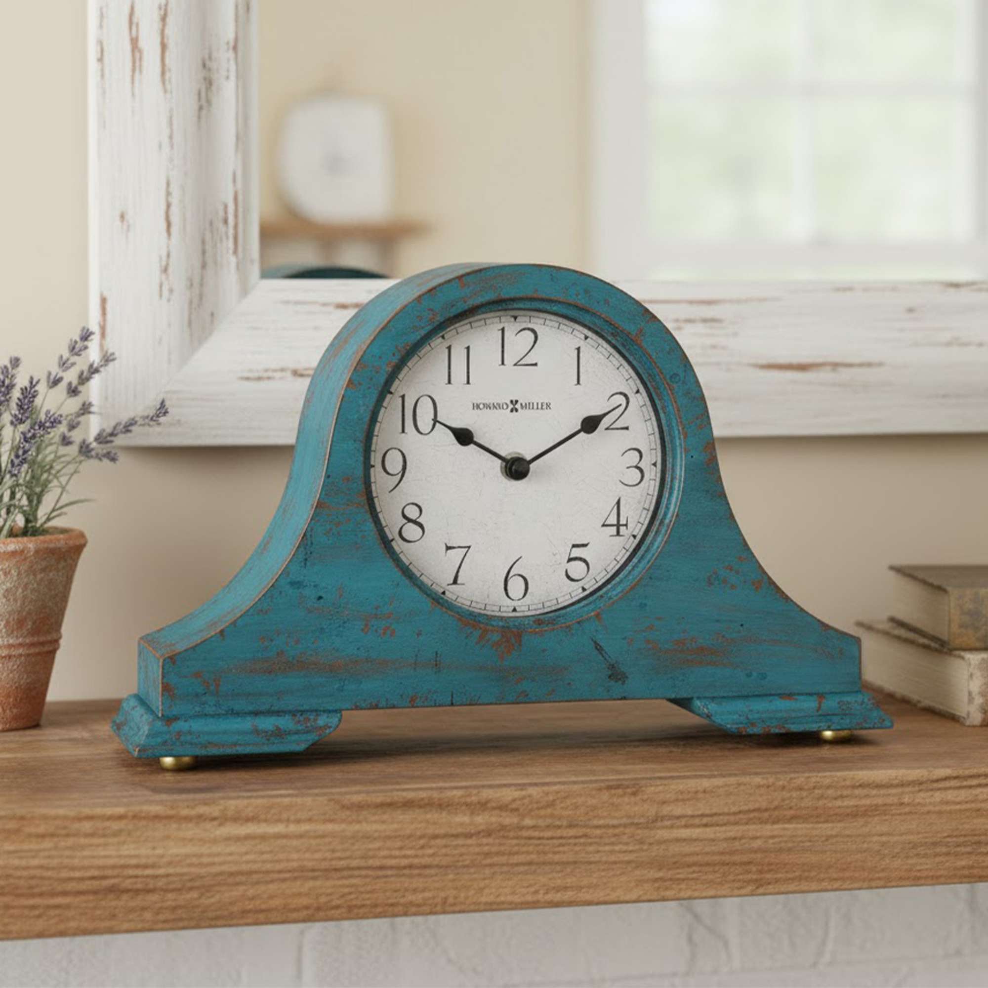 A vintage-style clock with a distressed turquoise finish, displayed on a wooden surface.
