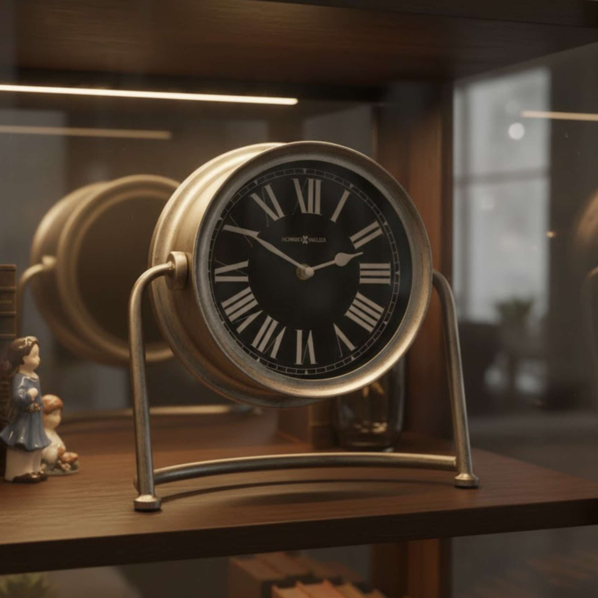 A vintage-style clock with a black face and Roman numerals displayed on a wooden shelf.