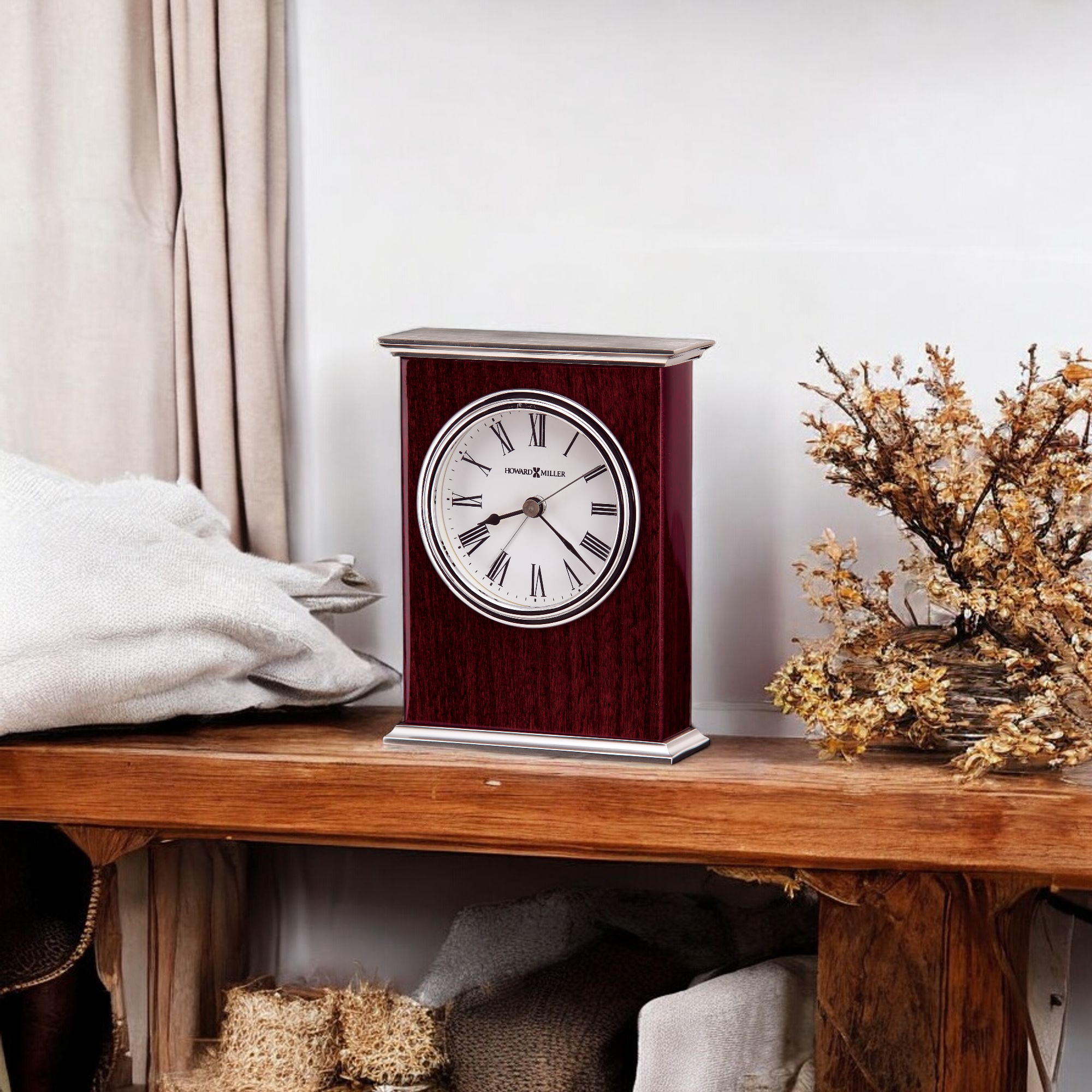 A vintage wooden clock displayed on a wooden shelf with decorative items.