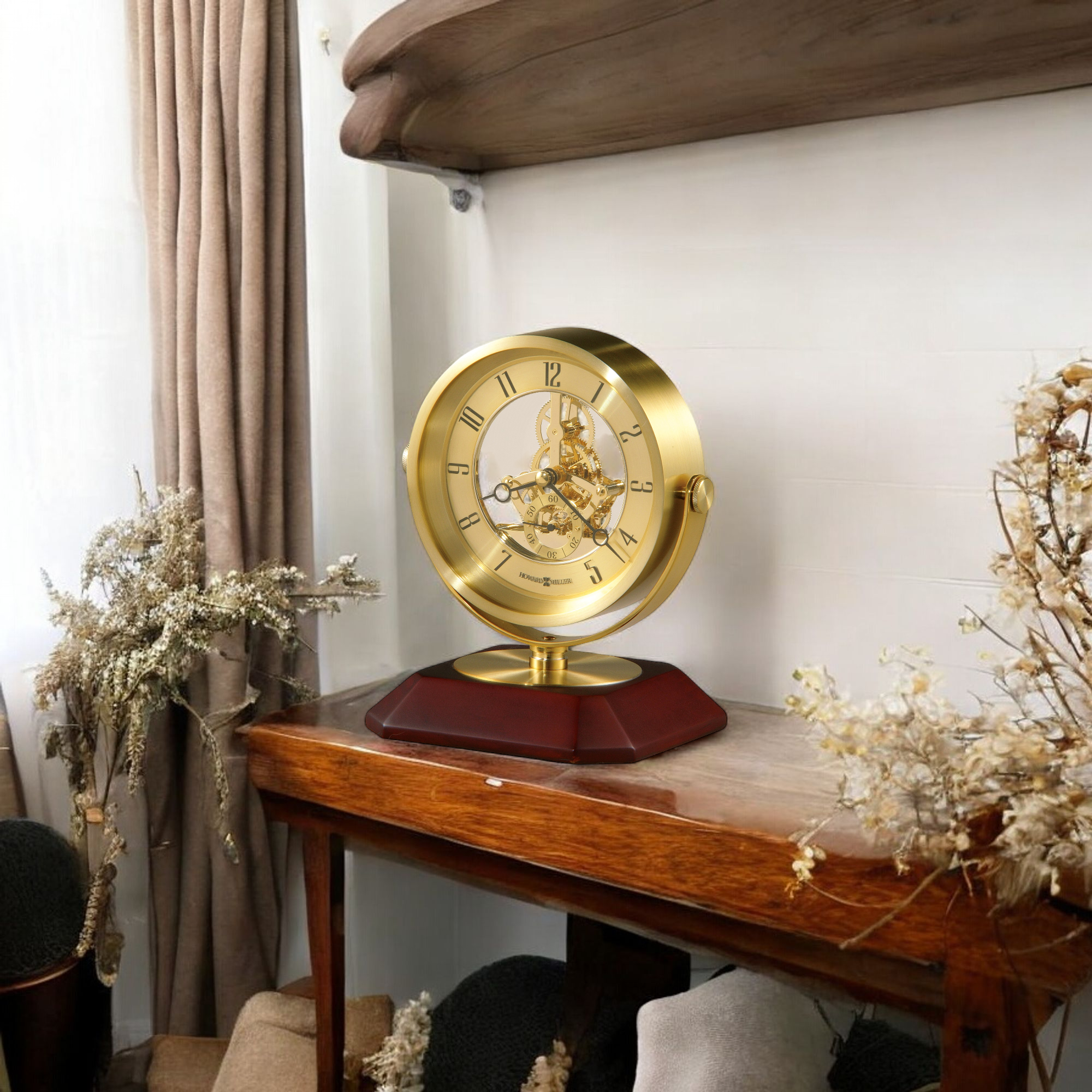 A vintage-style golden clock on a wooden table, surrounded by dried flowers.