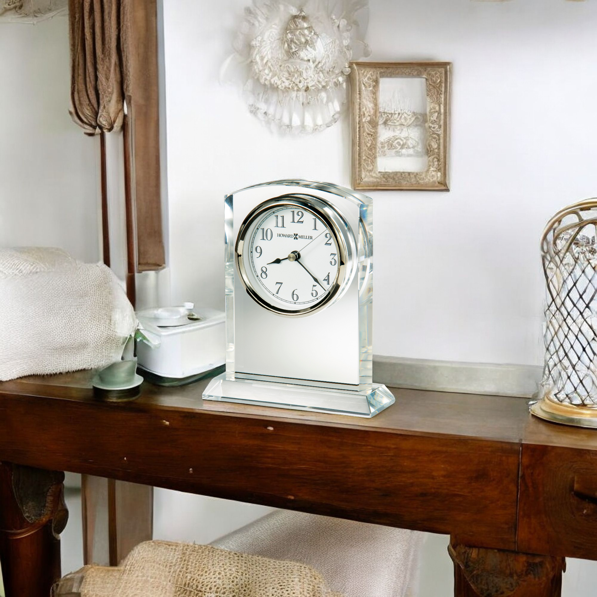 A stylish silver clock on a wooden table in a cozy room setting.