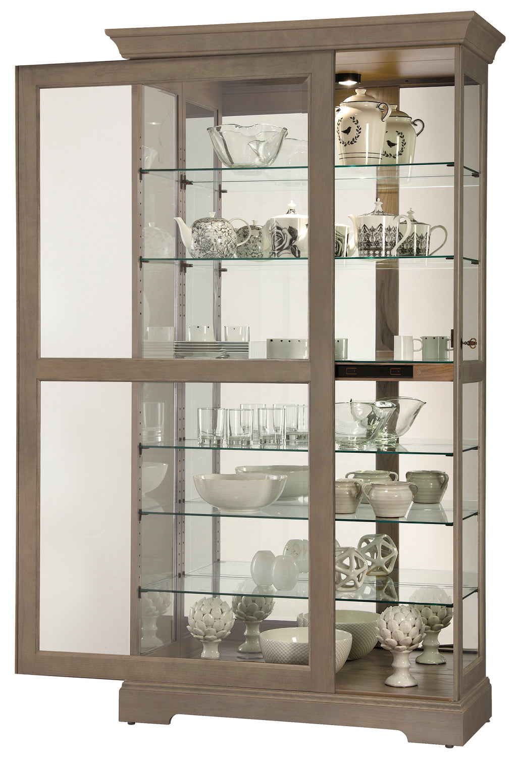 A wooden display cabinet with glass shelves showcasing various decorative items and tableware.