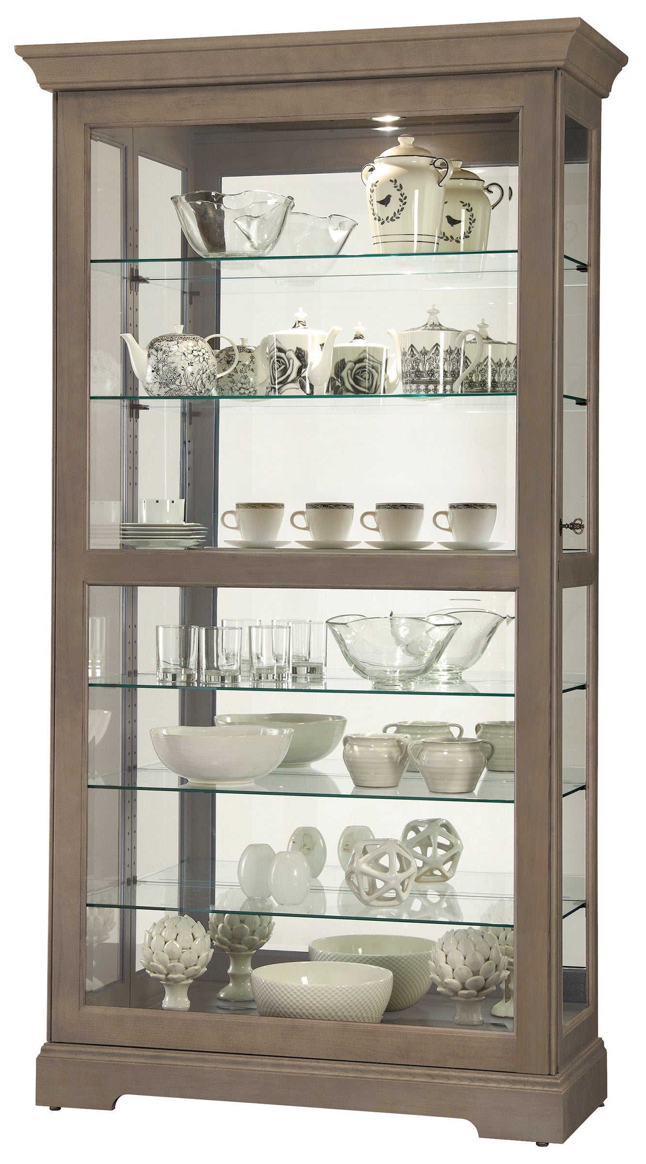 A wooden display cabinet showcasing various glassware, teapots, and decorative items on glass shelves.