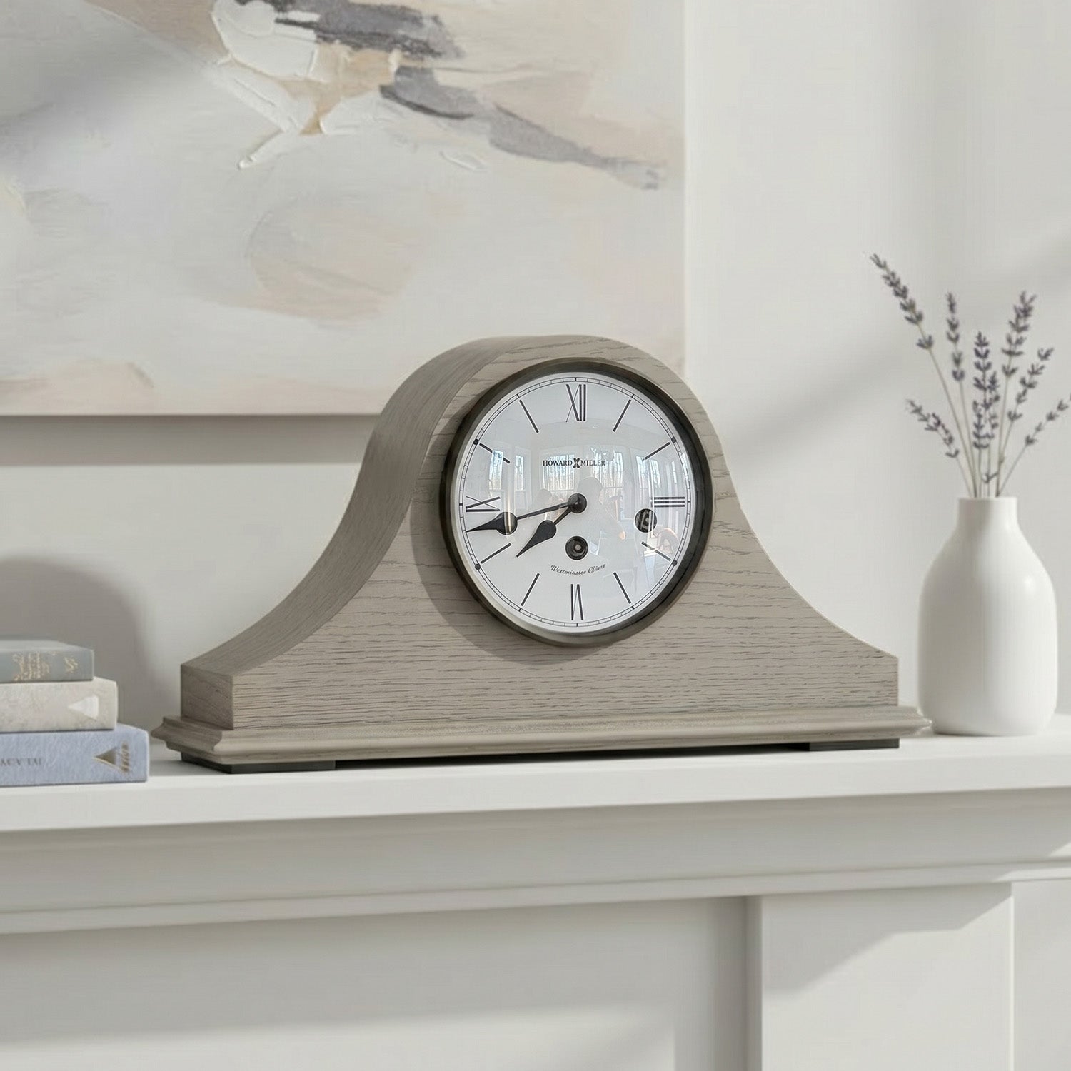 A decorative mantel clock with a subtle design, placed on a shelf with a vase and books.