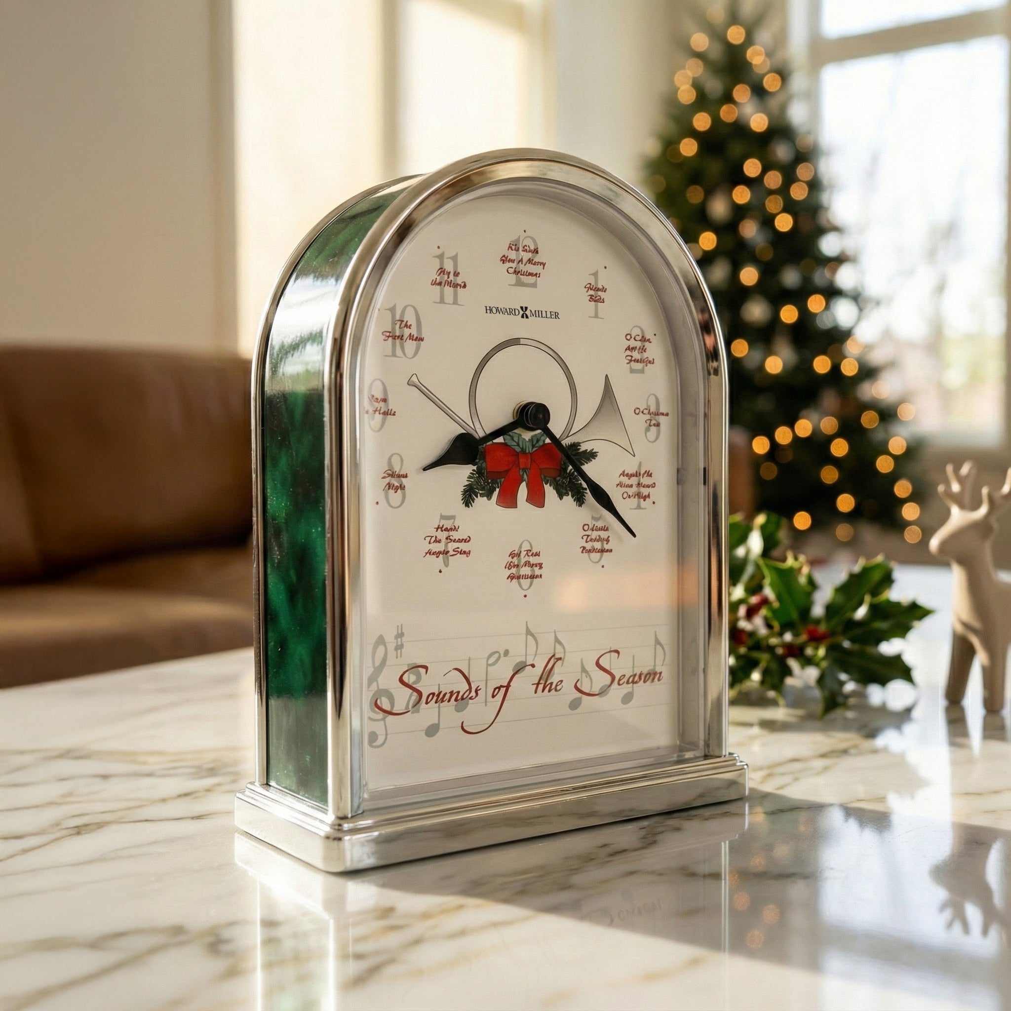Howard Miller musical clock, shiny silver finish, festive design displaying 'Sounds of the Season' with Christmas tunes.