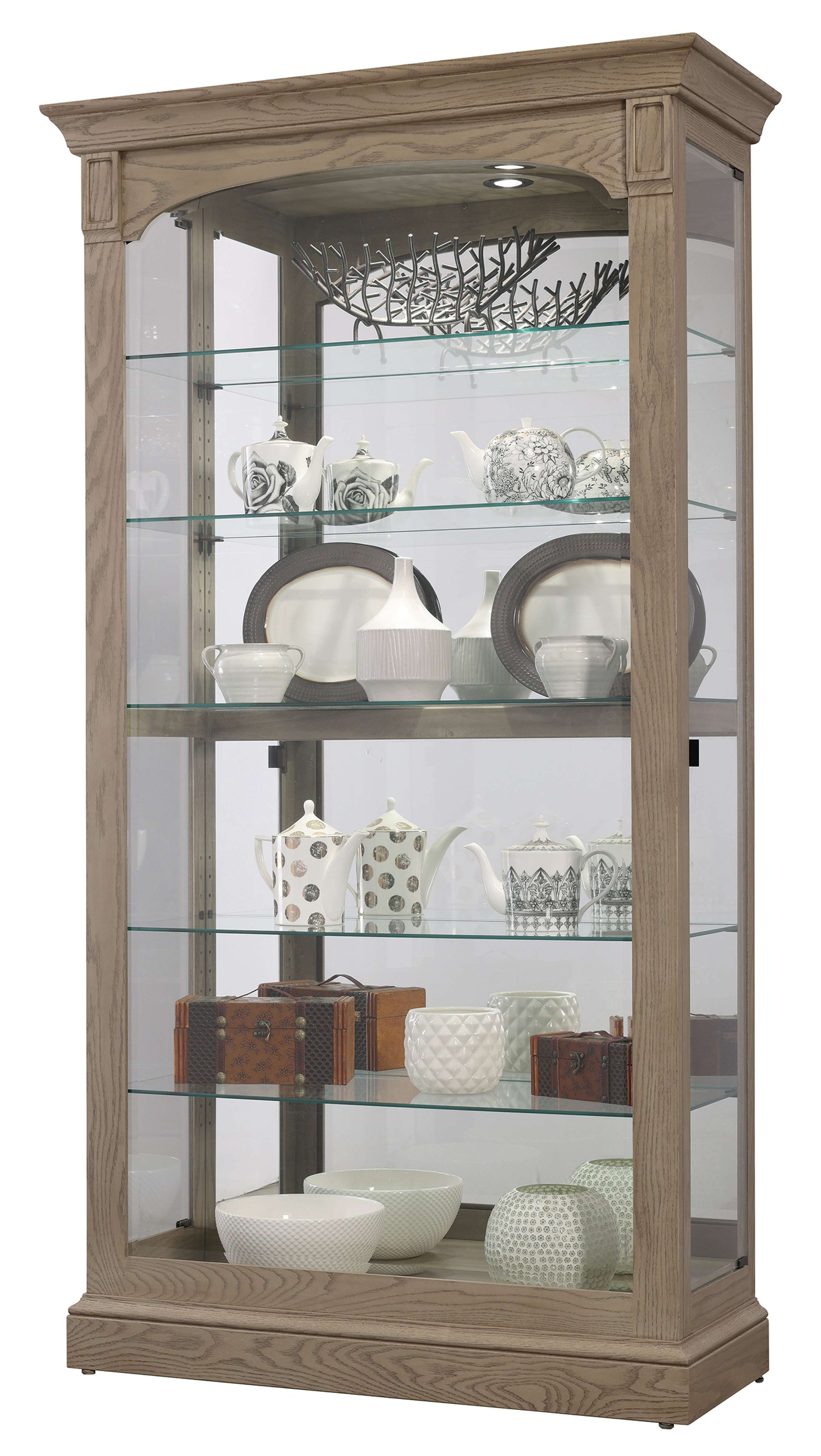 Display cabinet featuring glass shelves with various decorative dishes and teapots.