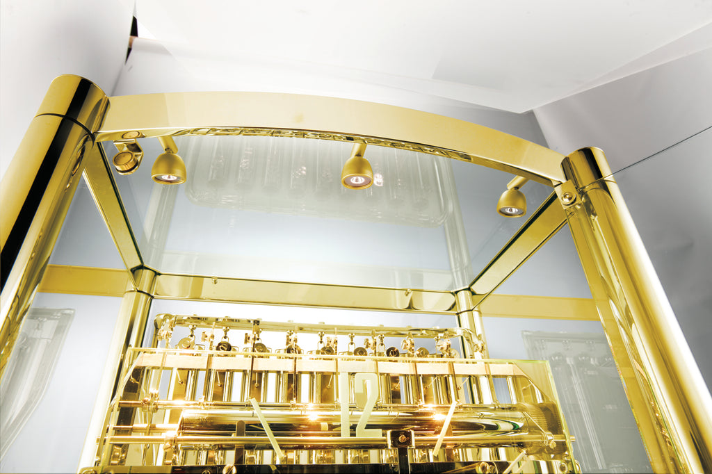 Close-up of a gold-colored display case with glass panels and spotlighting.