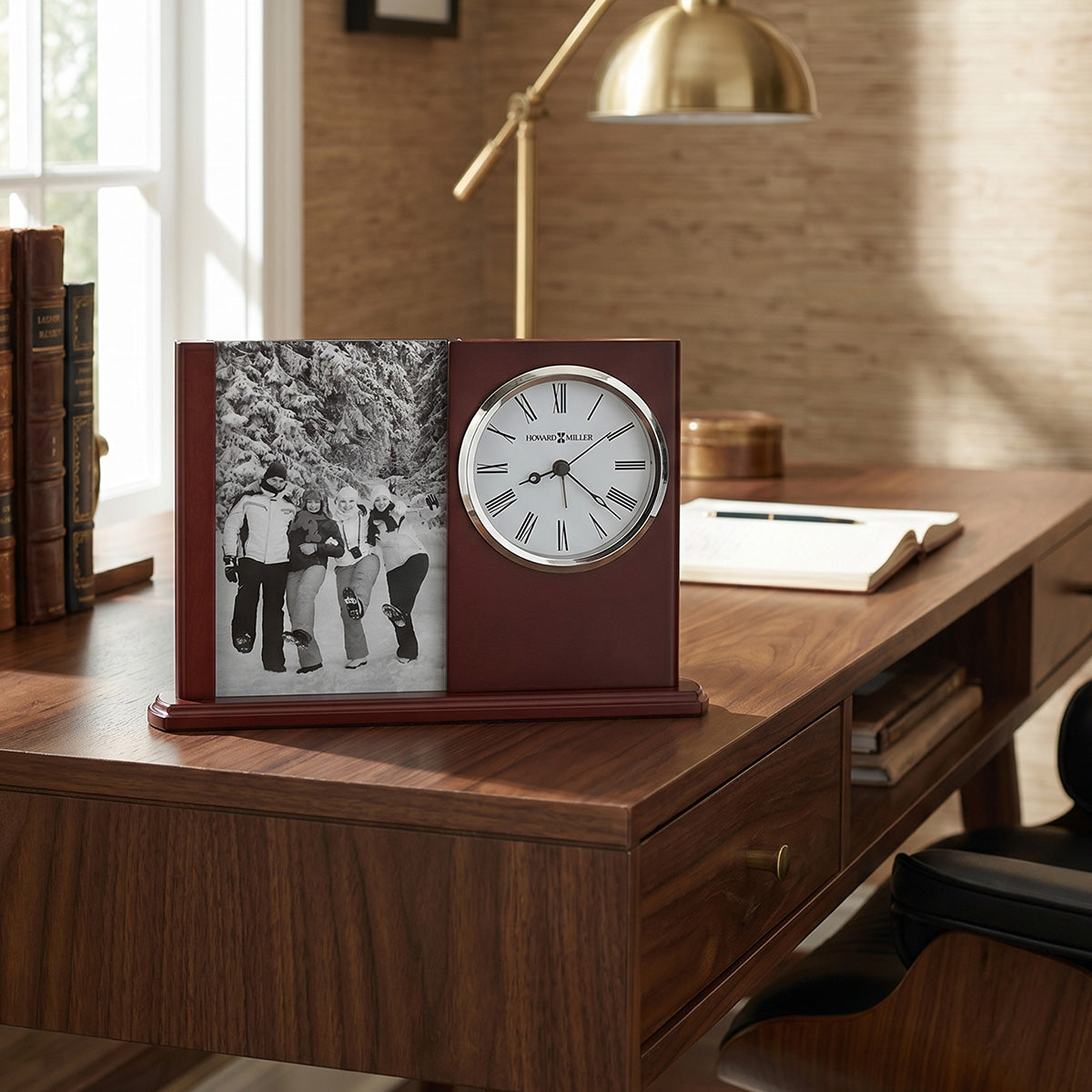 Wooden desk with clock, photo frame, and books in a home office setting