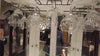 Reflection of glassware and a person in a display.