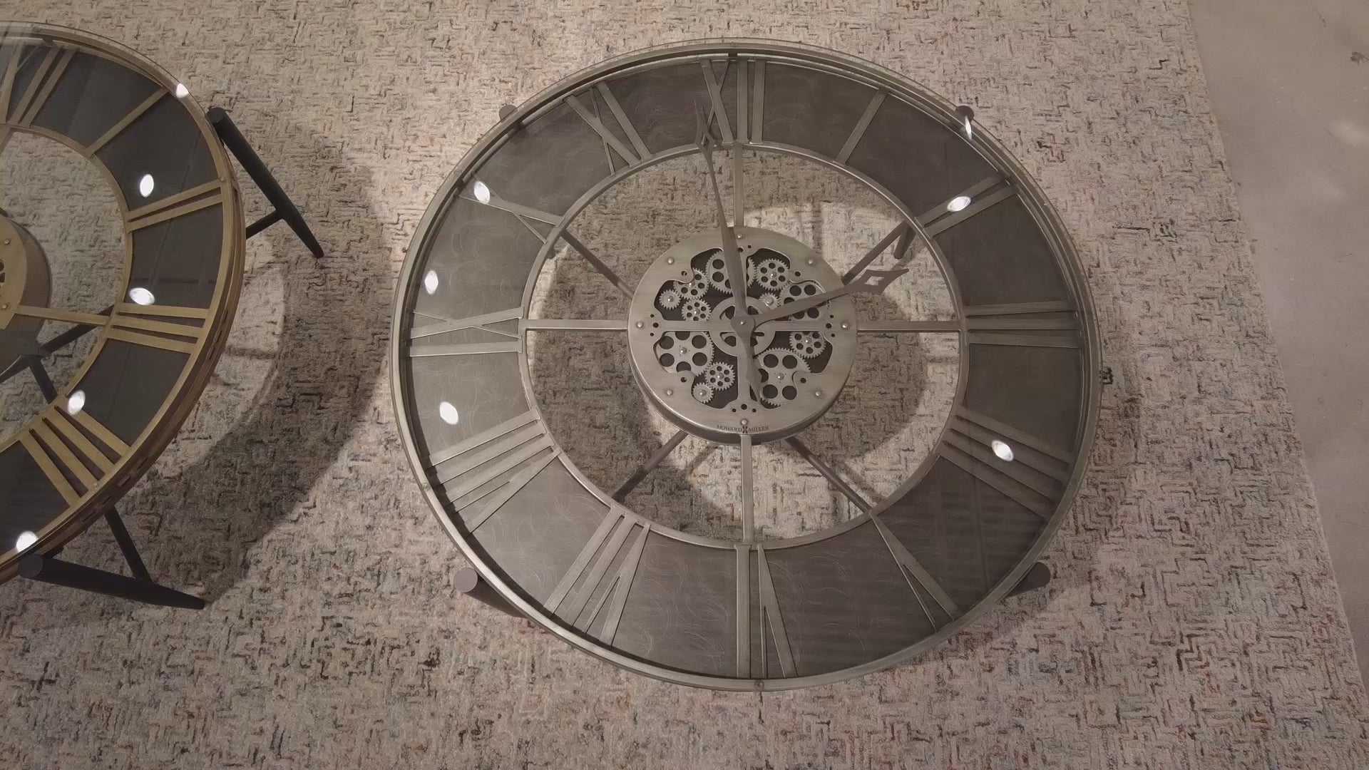 Top view of two intricate circular clock mechanisms on a textured surface.