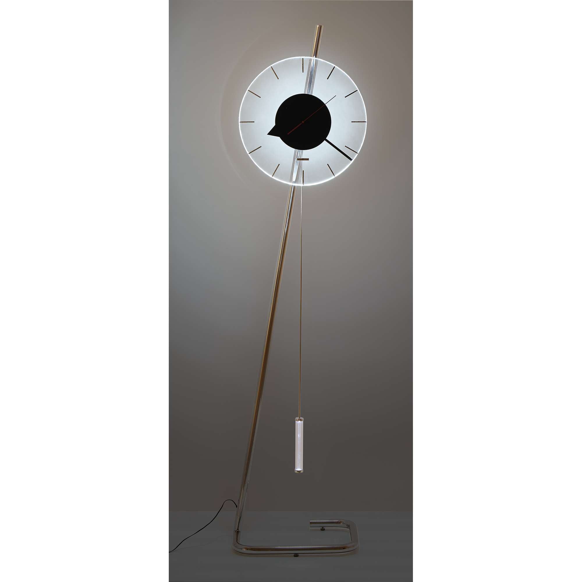 A modern floor clock with a circular design, featuring a black face and white hands, mounted on a minimalist wooden stand.